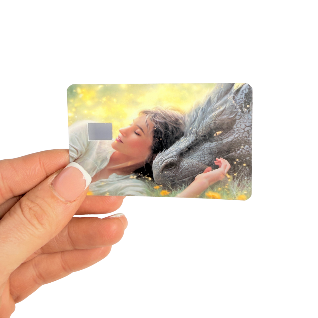 Soft fantasy illustration of a girl sleeping beside a large dragon printed on durable vinyl card skin."
