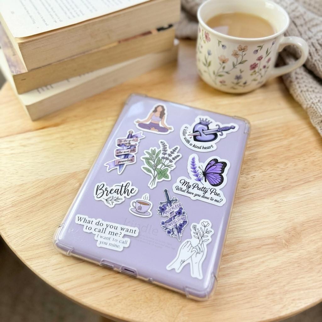 A clear lilac Kindle case covered in book boyfriend vinyl stickers, on a wooden table with a stack of vintage books, a floral mug of coffee, and a cozy knit throw. Decals include Breathe, a butterfly, botanical plants, a teacup, praying hands, and romantic book quotes. __etsy:8181760967