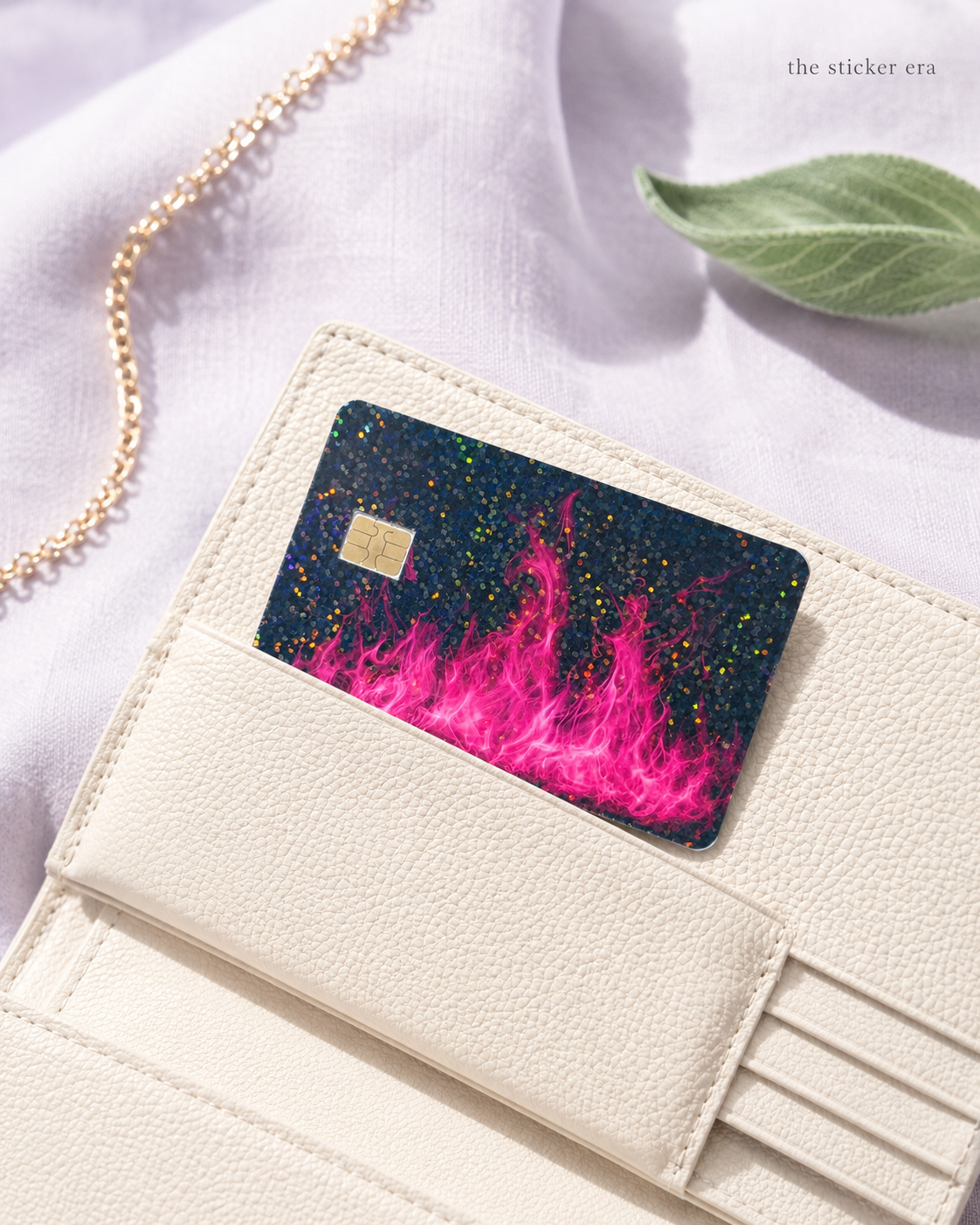 Holographic pink flame credit card skin sitting in a cream cardholder wallet by The Sticker Era