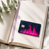 Hot pink flame debit card skin resting on an open journal with greenery by The Sticker Era