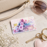 Pastel floral book card skin beside a cream handbag with sunglasses, keys and baby's breath by The Sticker Era
