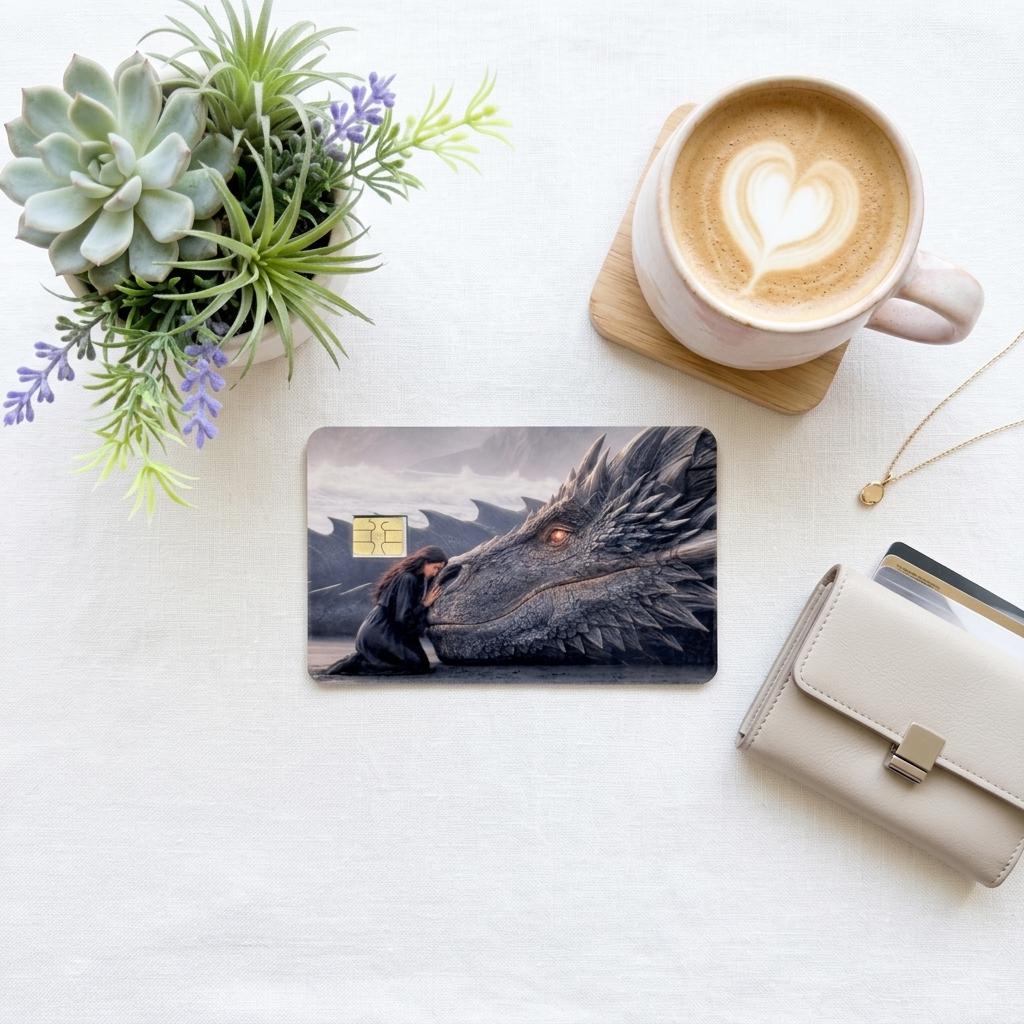 a debit card skin of a black dragon laying it's head down so a human can rest her head on the dragon on a cream colored cloth,  and a wallet 
flower and a hot coffee
 made by thestickerera __etsy:8156746605