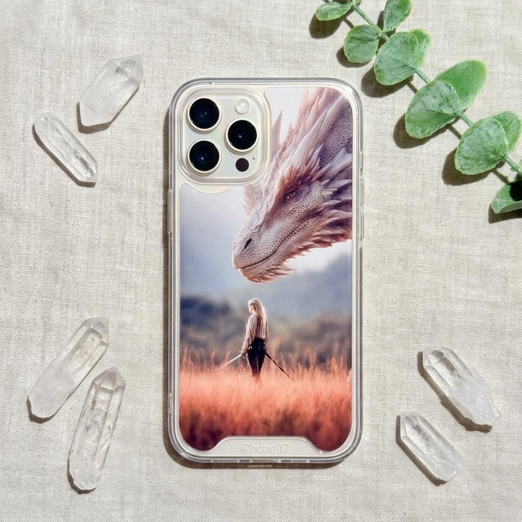iPhone in a clear case showing fantasy dragon art, a silver dragon above a woman in a golden grass field, arranged with clear quartz crystals and eucalyptus on a linen background. __etsy:8116031652