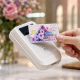 Hand tapping a pastel floral book card skin on a white payment terminal with pink roses in the background by The Sticker Era
