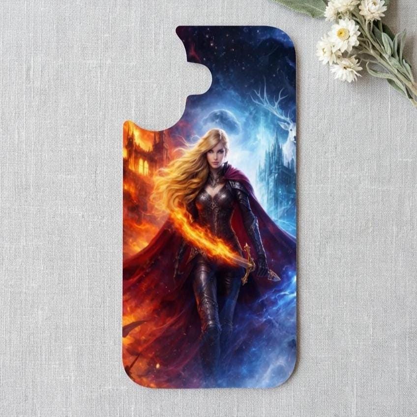 Fire and ice fantasy warrior goddess art printed on a clear phone case insert. A blonde woman in dark armor and a flowing red cape wields flames on one side and icy blue magic on the other, set against a snowy castle and starry sky. The insert rests on a light linen background with white daisies. __etsy:8165469525