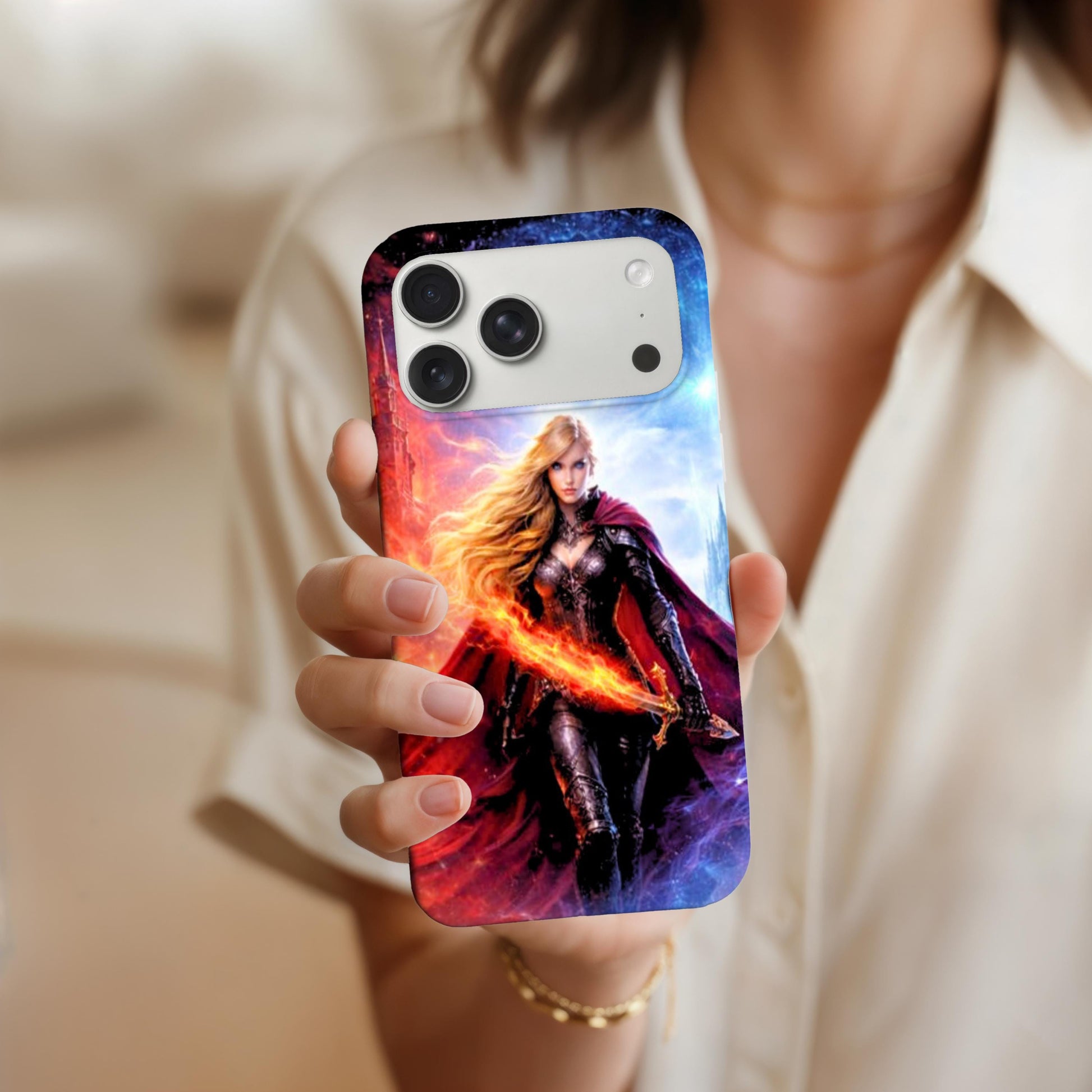 May include: A smartphone case featuring a fantasy warrior with long blonde hair, a red cape, and a glowing sword. TA person in a cream blouse holding up a phone to show the clear case featuring the fire and ice fantasy warrior goddess art facing the camera, with a gold bracelet on their wrist.he case has a gradient background of red, orange, blue, and white. The phone has three camera lenses. __etsy:7734506183