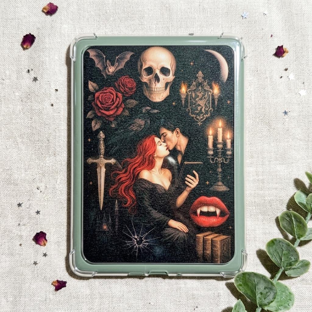 Gothic vampire Kindle insert decal shown on a sage green e-reader case, styled with scattered dried rose petals, star confetti, and eucalyptus on linen. The dark romantasy design features a red-haired woman and a vampire embracing with a skull, roses, a dagger, and candles. __etsy:8109554496