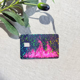 Angled view of hot pink flame card skin showing rainbow holographic speckles by The Sticker Era