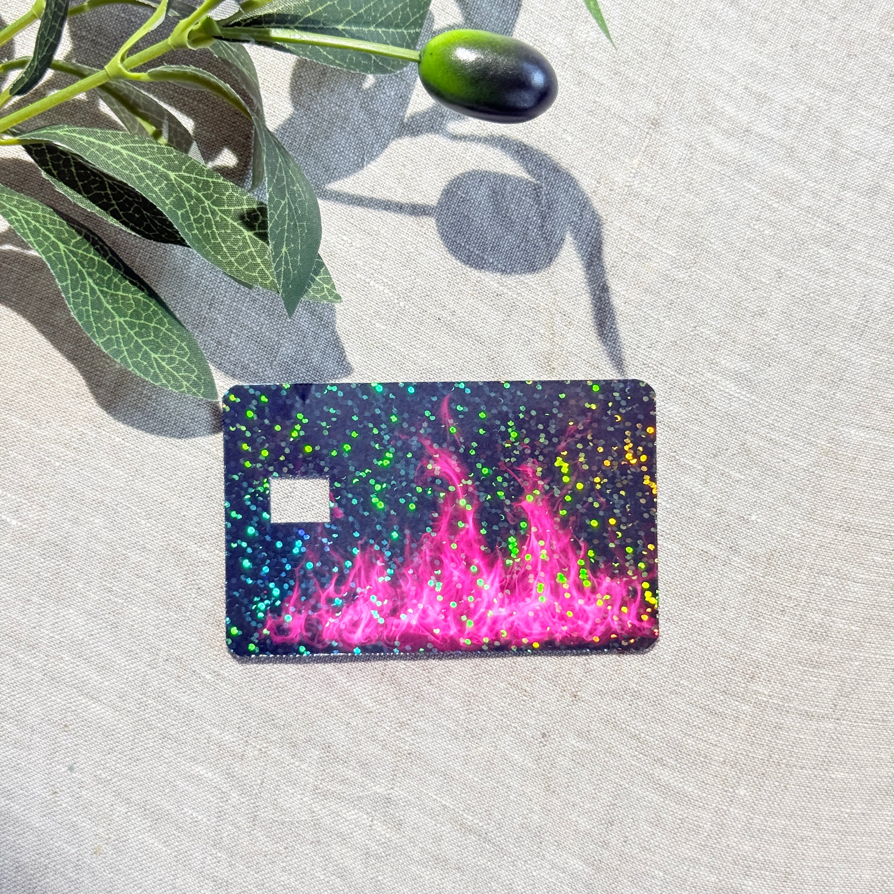 Angled view of hot pink flame card skin showing rainbow holographic speckles by The Sticker Era