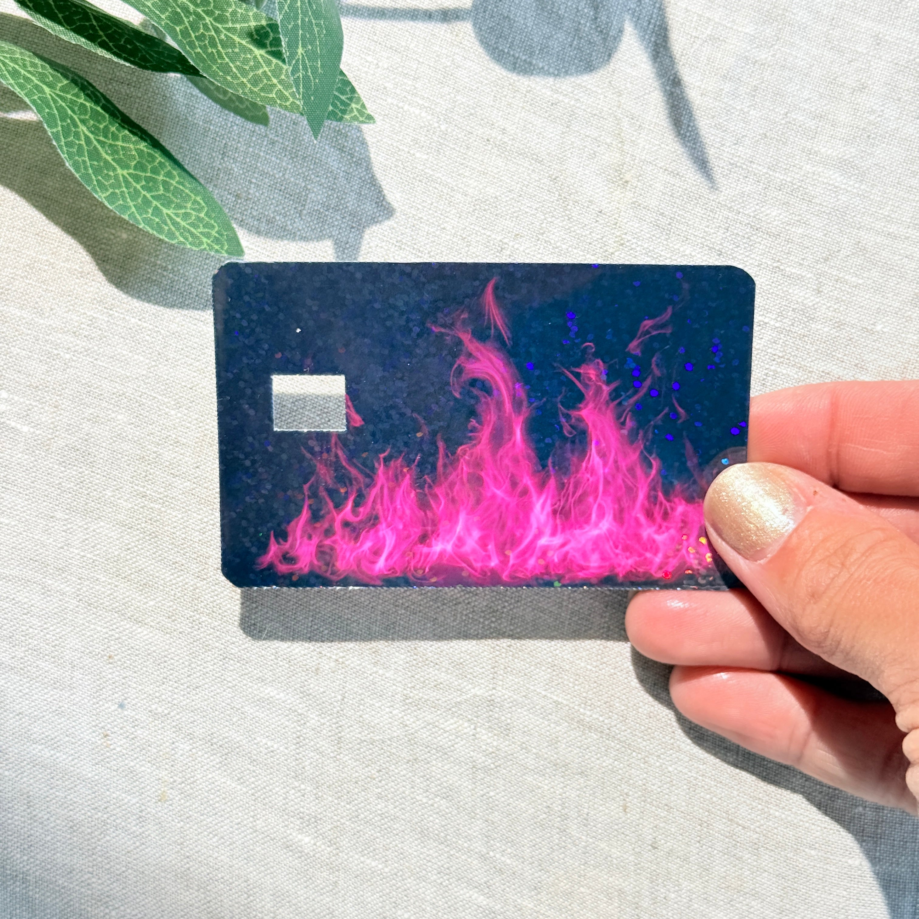 Hot pink flame card skin held up to show holographic glitter shimmer by The Sticker Era