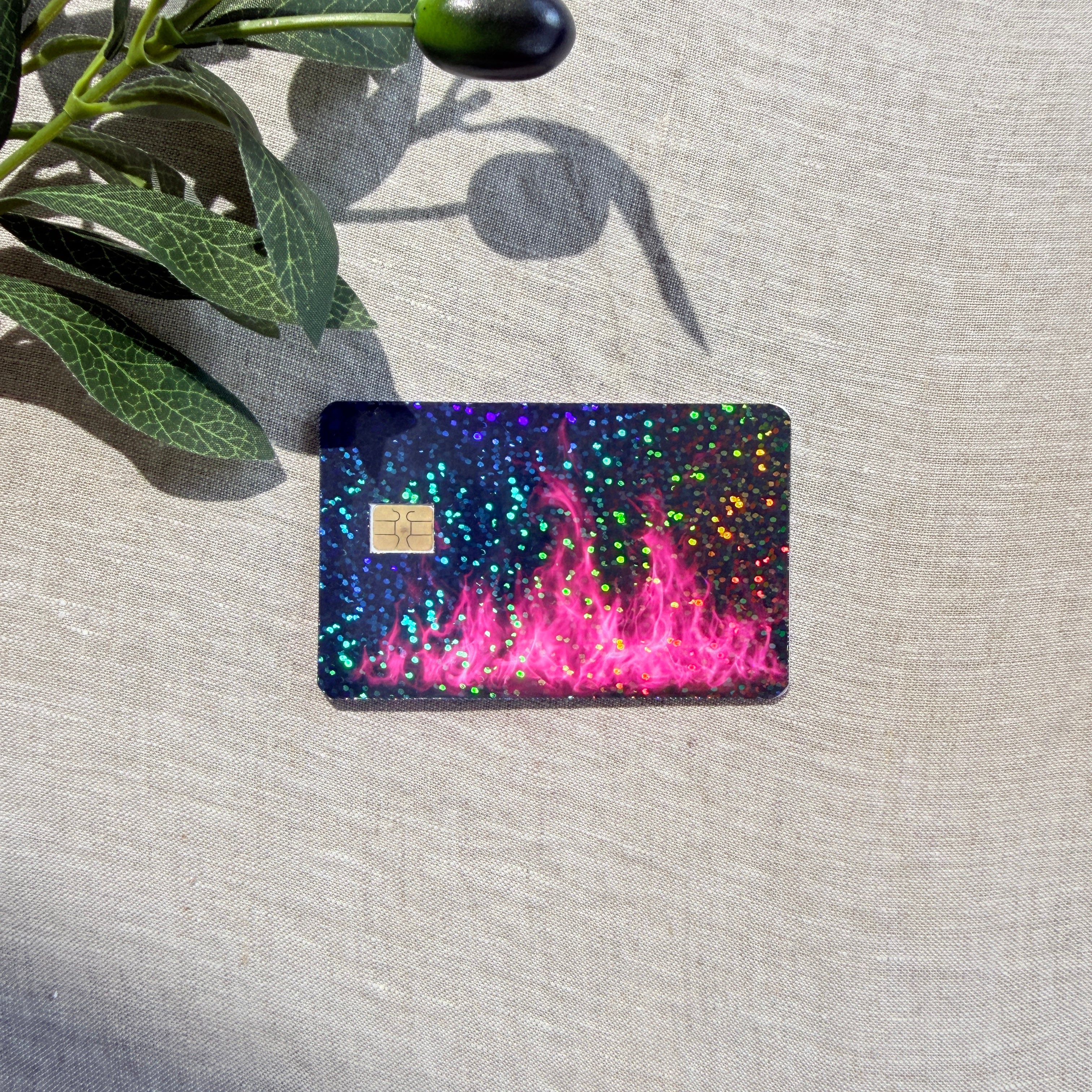 Close-up of hot pink flame card skin with holographic sparkle in natural sunlight by The Sticker Era