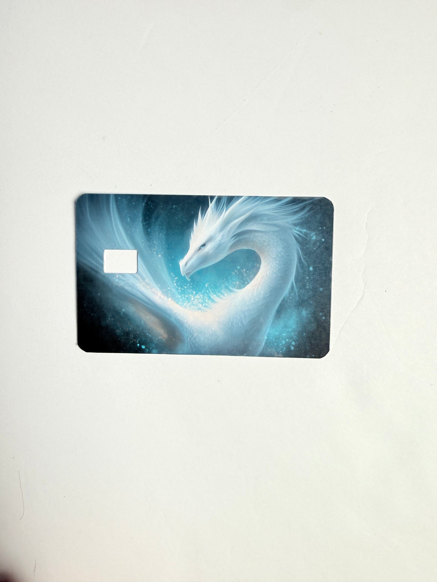 Celestial ice dragon debit card skin sticker, blue ethereal fantasy art decal for credit cards.
