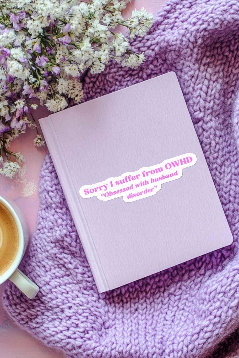 The "Sorry I suffer from OWHD - Obsessed with husband disorder" sticker on a soft lilac journal. Styled on a chunky lavender knit blanket with sprigs of white baby's breath and a latte in the corner. __etsy:7819782867
