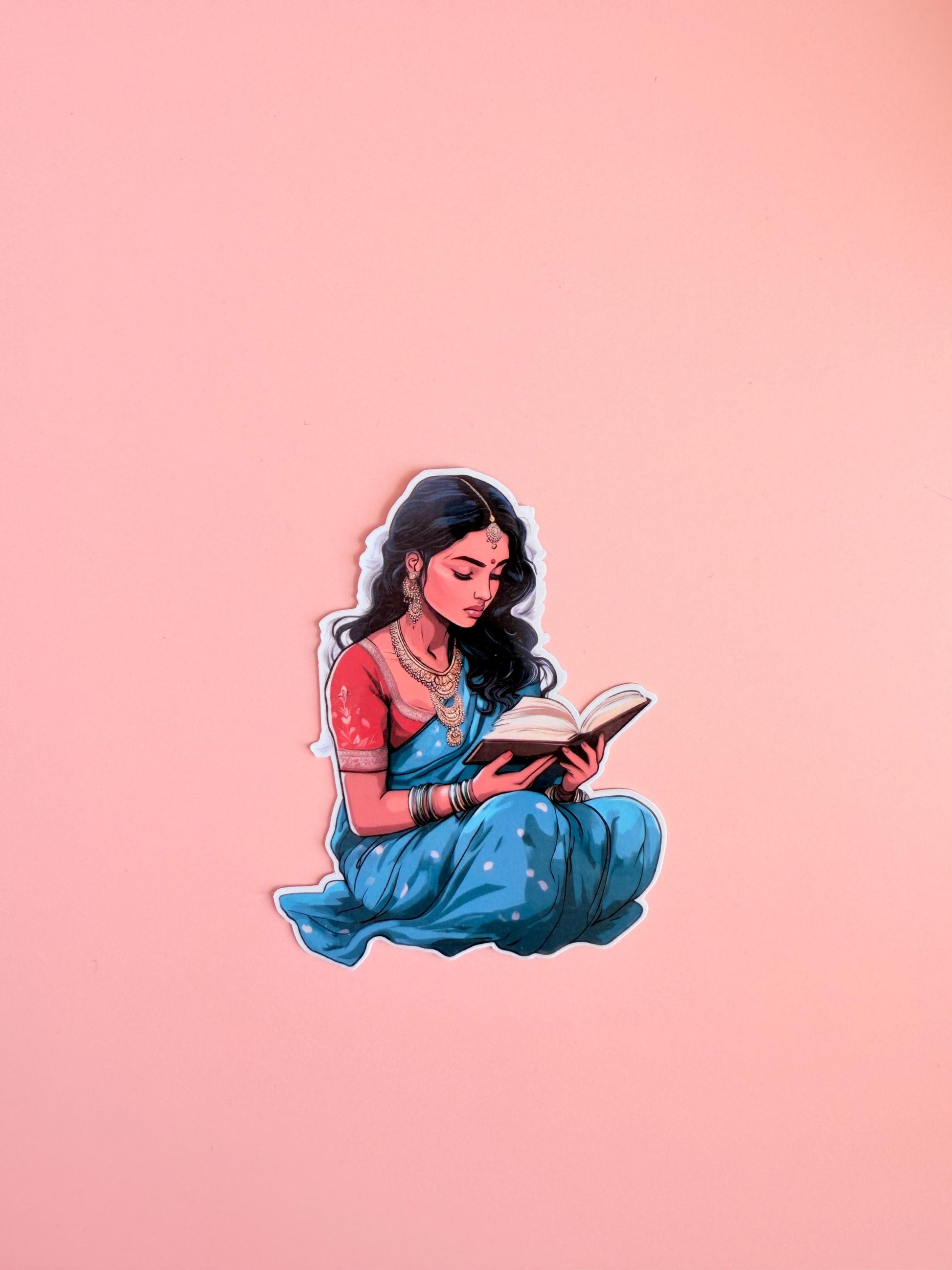 Woman in blue and red traditional attire reading a book, adorned with gold jewelry. Bookish art-style sticker on a pink background. __etsy:6893037408