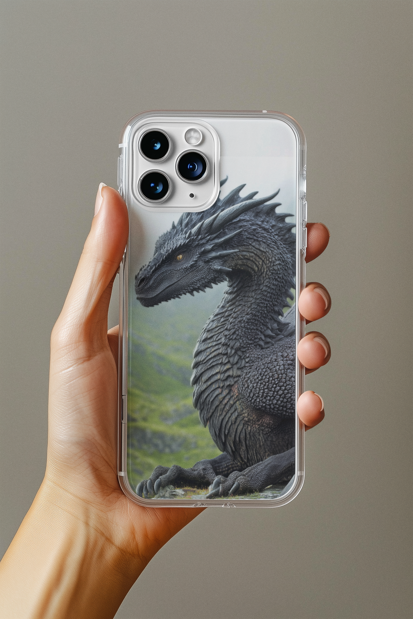 Hand holding an iPhone 17 Pro Max with a clear case featuring a premium fantasy black dragon art insert