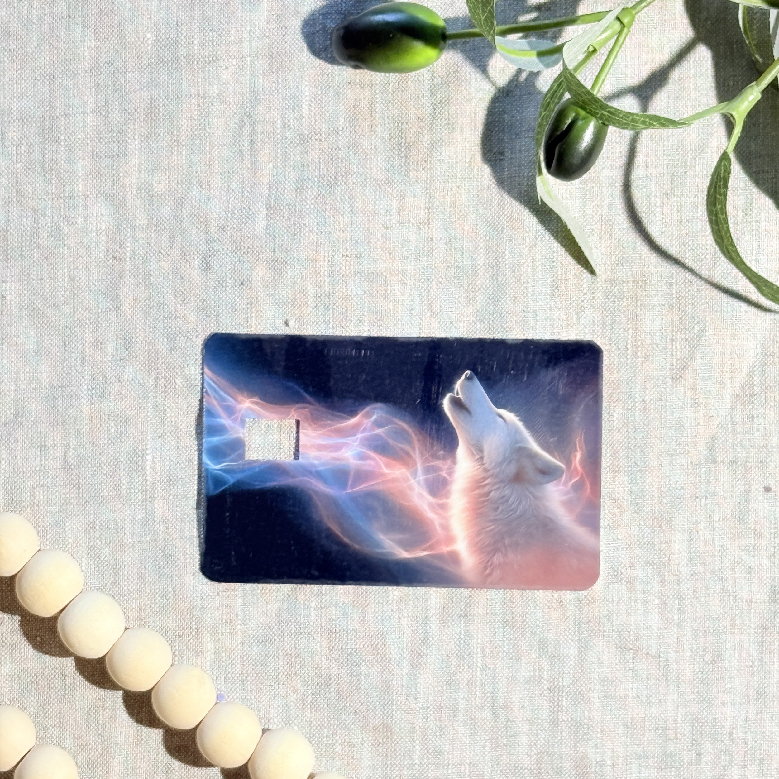 Hand holding the aurora wolf card skin in sunlight by The Sticker Era