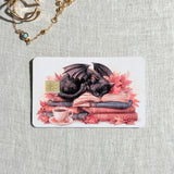 Cozy books and coffee debit card sticker shown flat on linen