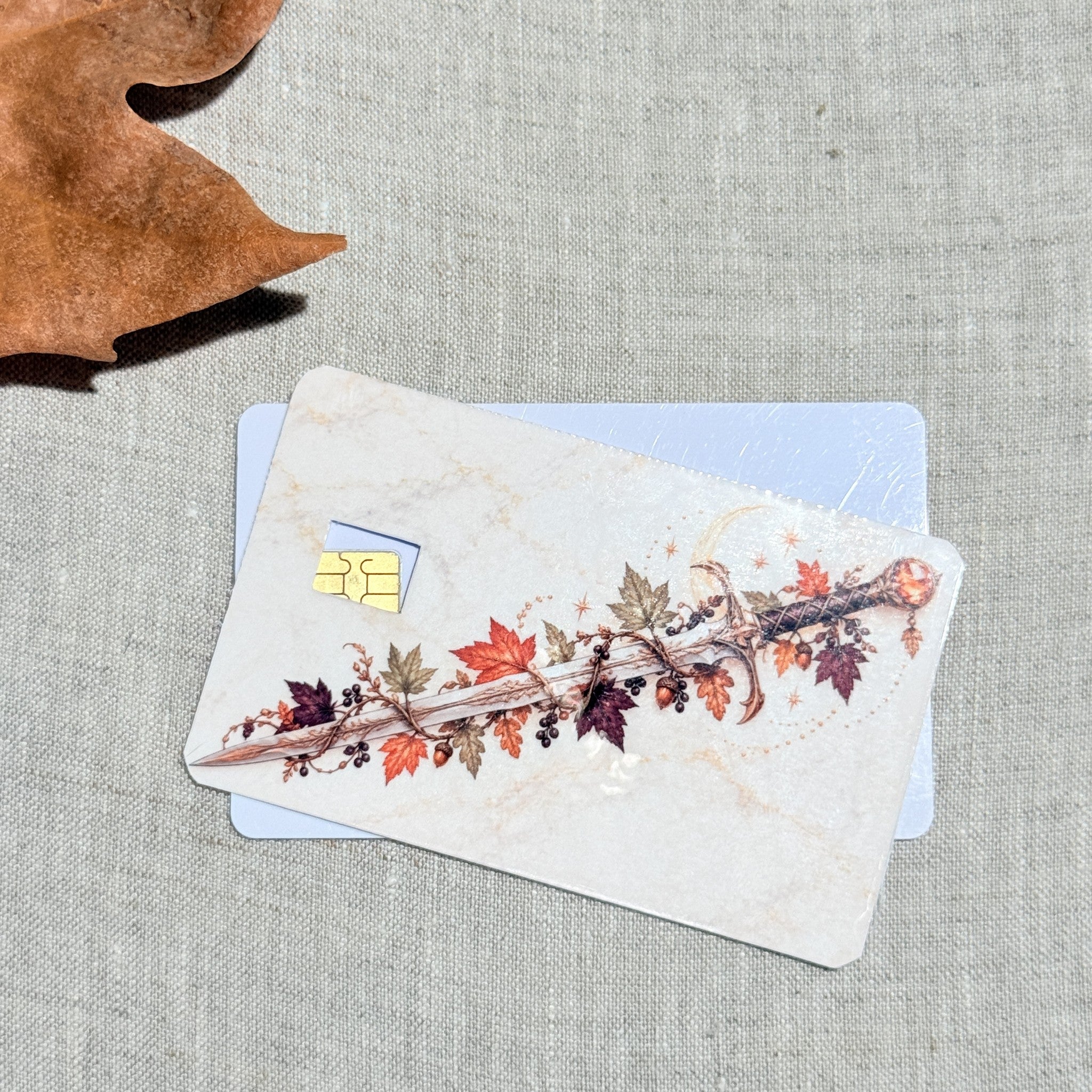 Two autumn sword card skins stacked to show the standard and sparkle finishes