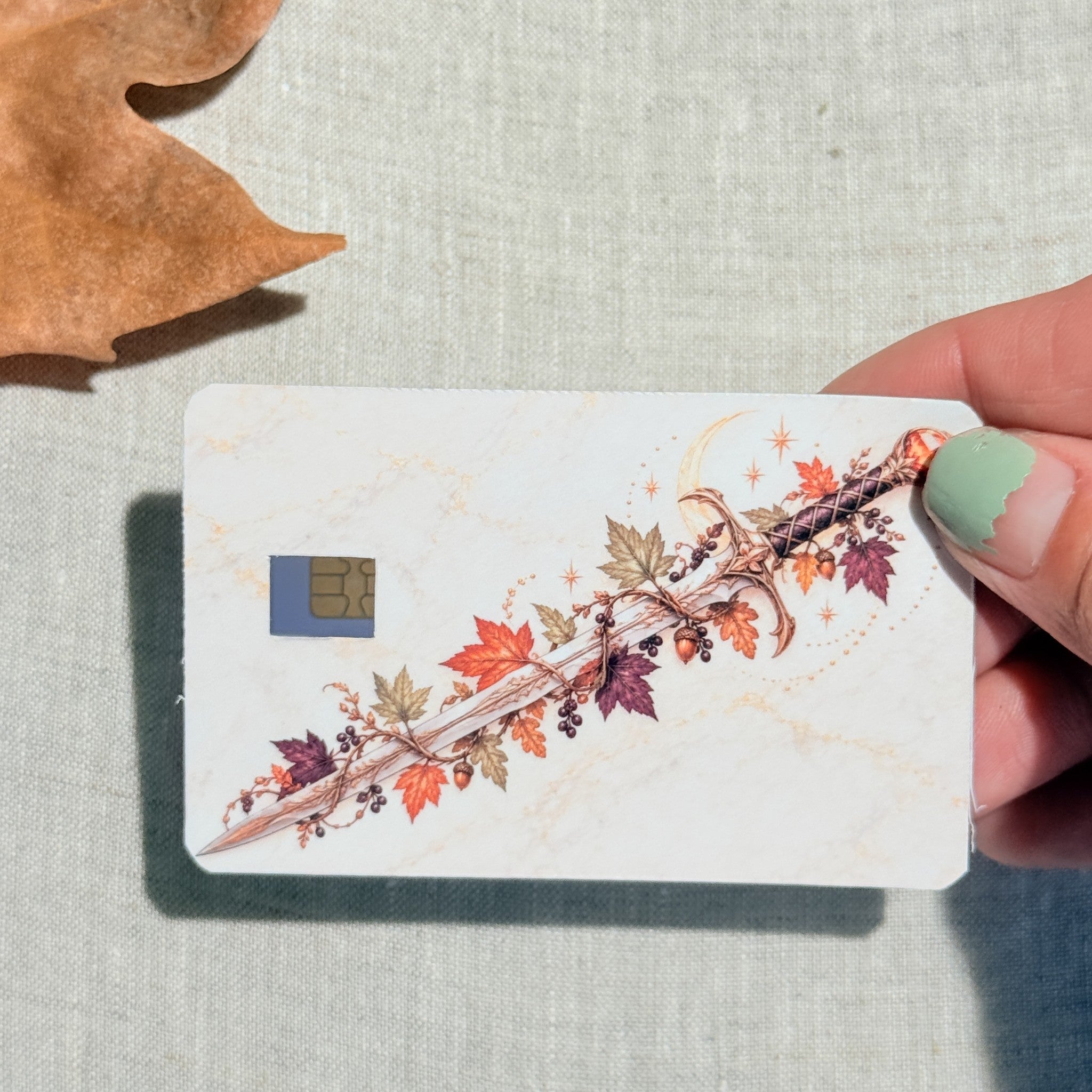 Autumn sword card skin held in hand for scale