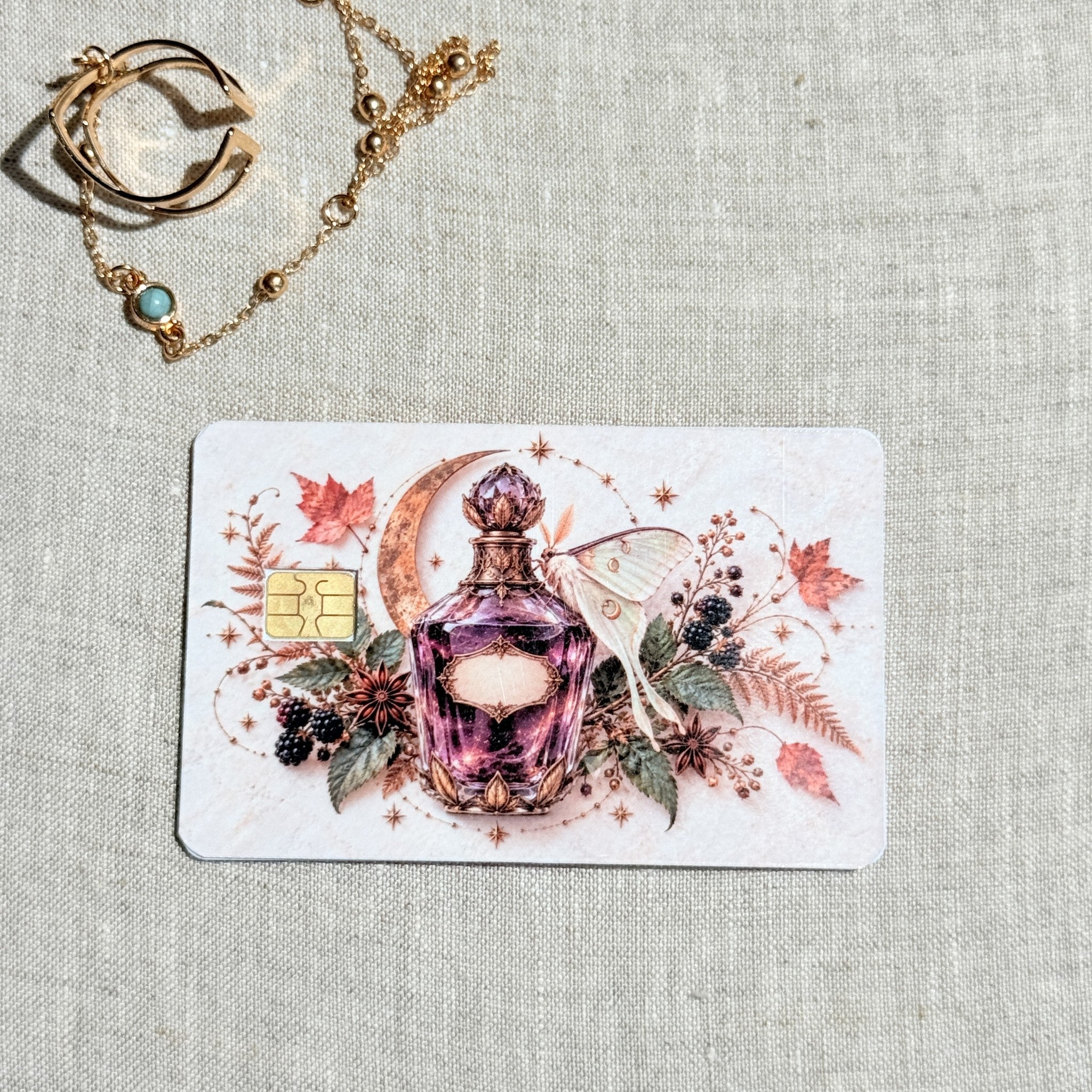 Moth and moon apothecary debit card sticker shown flat on linen