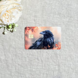 Autumn raven card skin with a black raven among orange fall leaves on a debit card by The Sticker Era