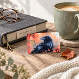 Raven fall leaves card skin on a wood table with coffee, a book and reading glasses by The Sticker Era