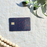 Black glitter card skin with holographic sparkle on a black debit card by The Sticker Era