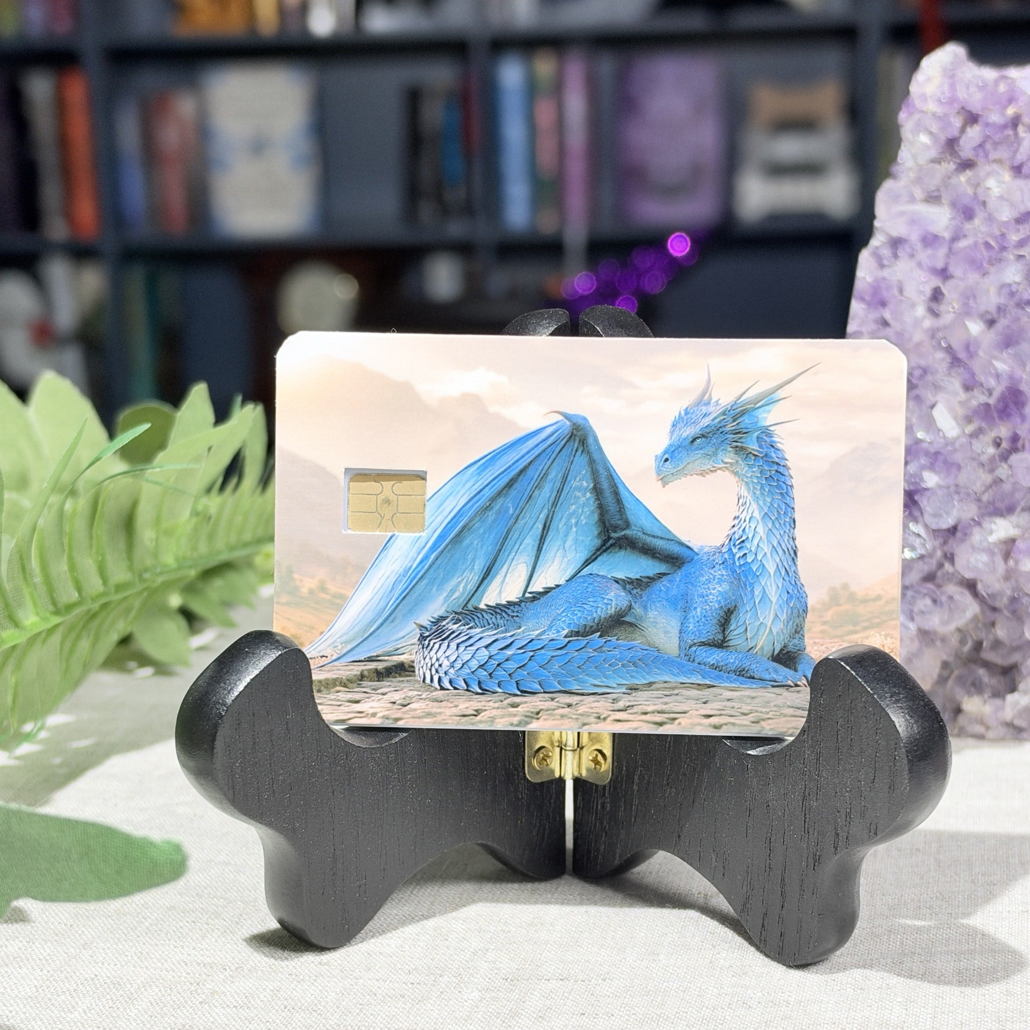 Blue dragon credit card skin on a display stand, sapphire dragon resting on stone, by The Sticker Era