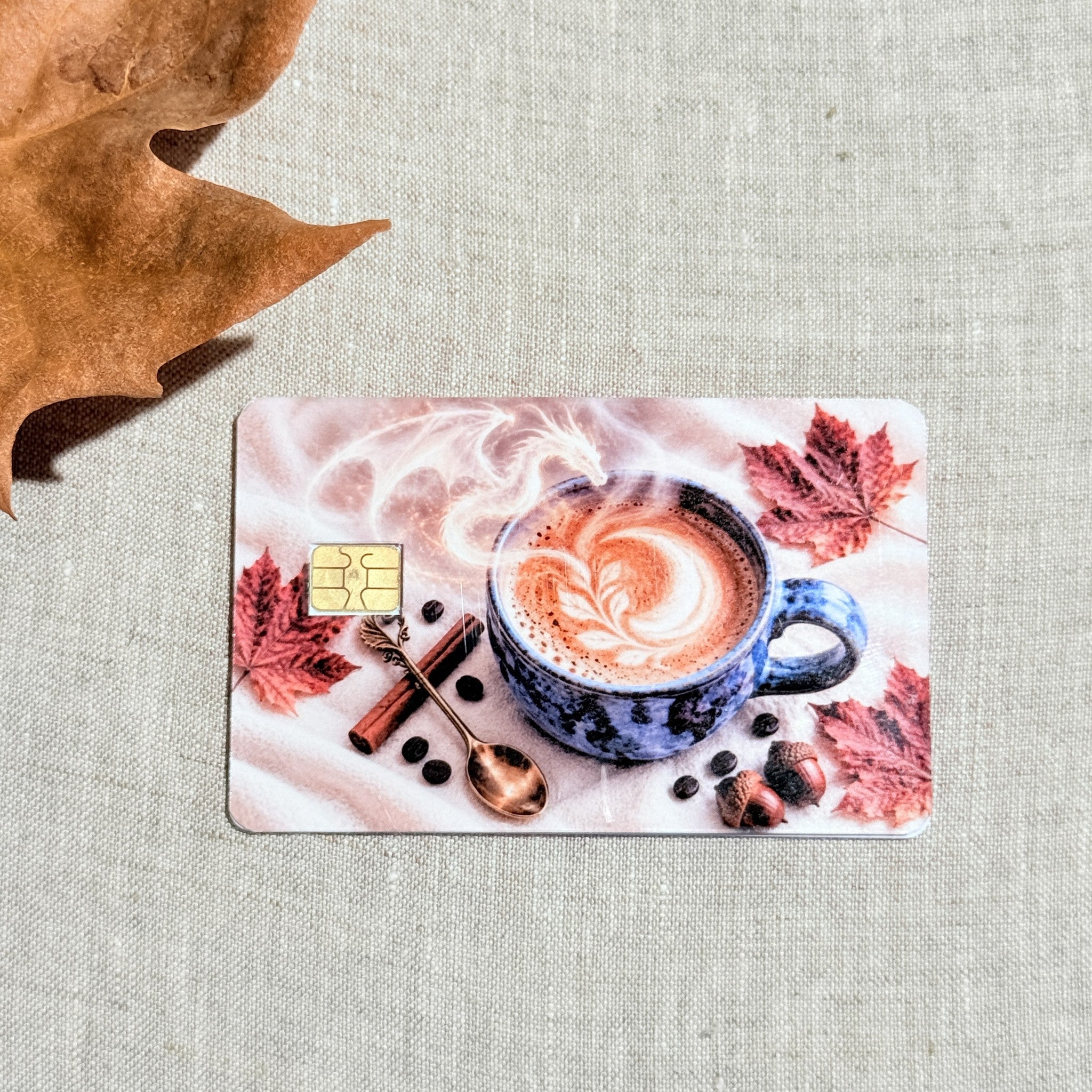 Blue mug and maple leaves debit card sticker shown flat on linen