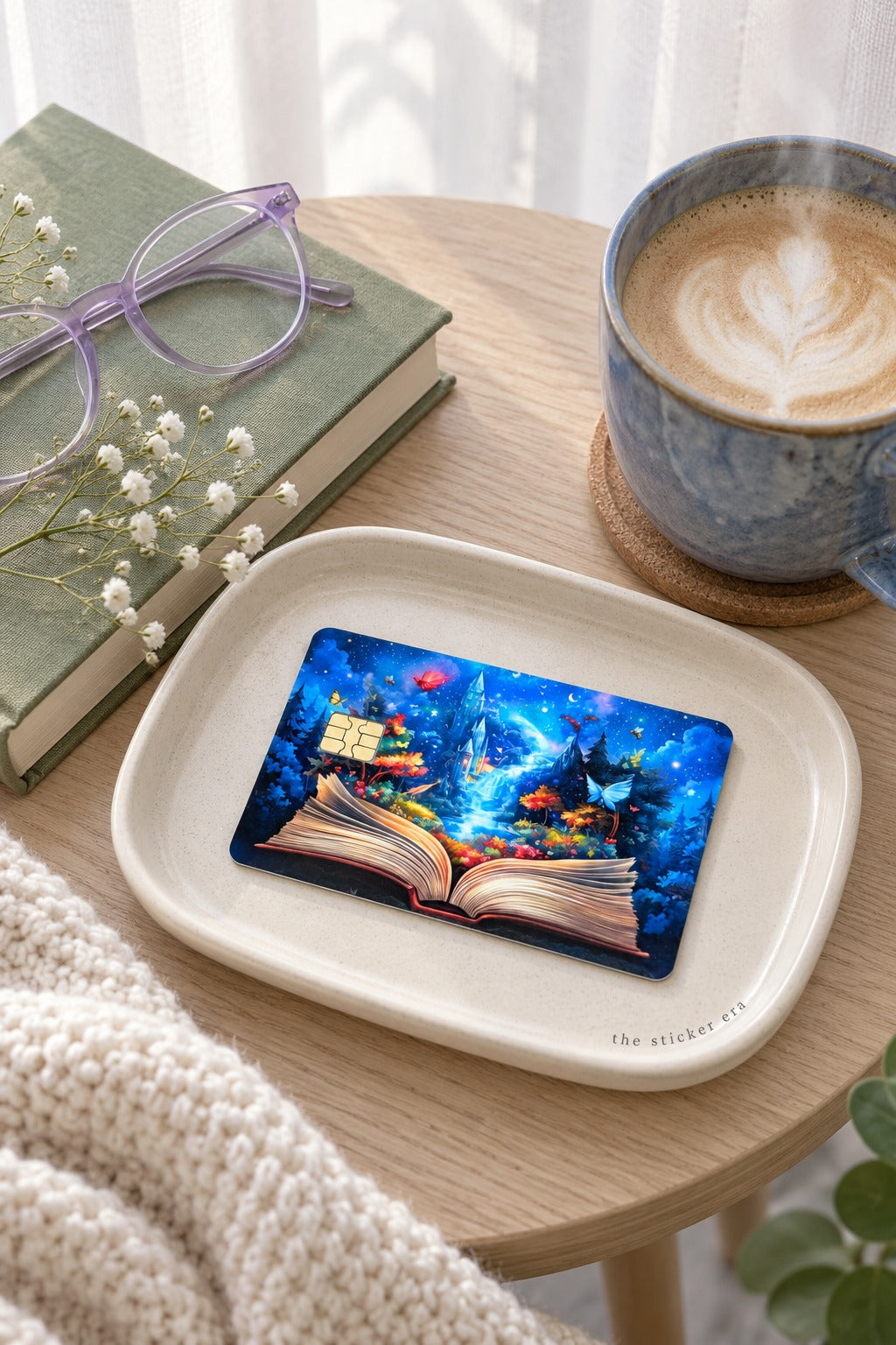 Enchanted storybook card skin on a cream tray beside a latte and lavender reading glasses by The Sticker Era