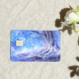 Enchanted blue tree debit card skin flat lay on cream linen by The Sticker Era