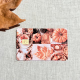 Orange fall collage debit card sticker shown flat on linen