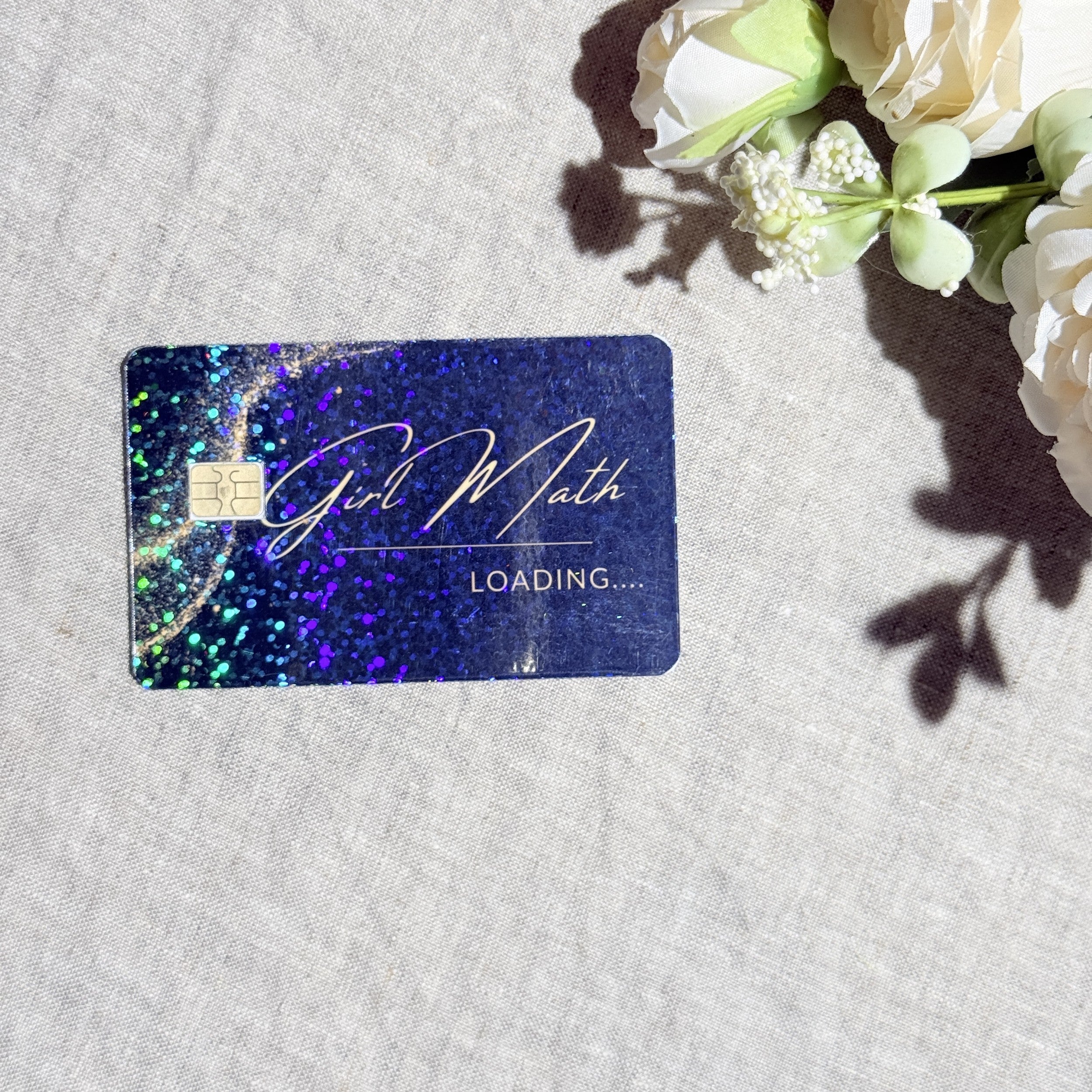 Girl Math Loading card skin with gold script and holographic sparkle on a navy debit card by The Sticker Era