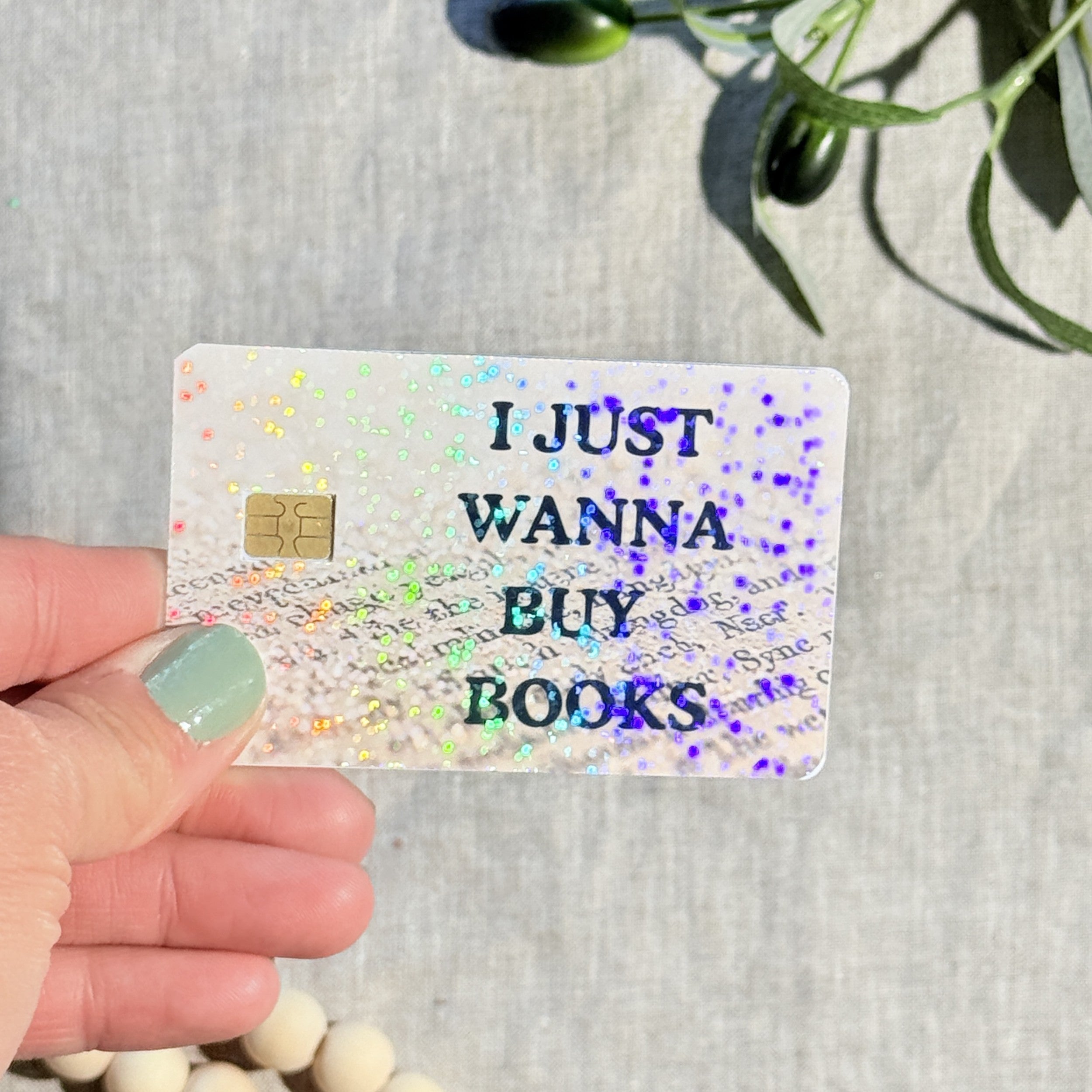 I Just Wanna Buy Books card skin held at an angle by The Sticker Era