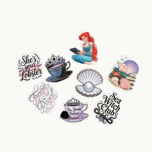 An 8-piece vinyl sticker set featuring fantasy and royal-themed designs, including a mermaid reading, gothic teacups, pearls, seashells, and elegant quote stickers, displayed on a pink background."
