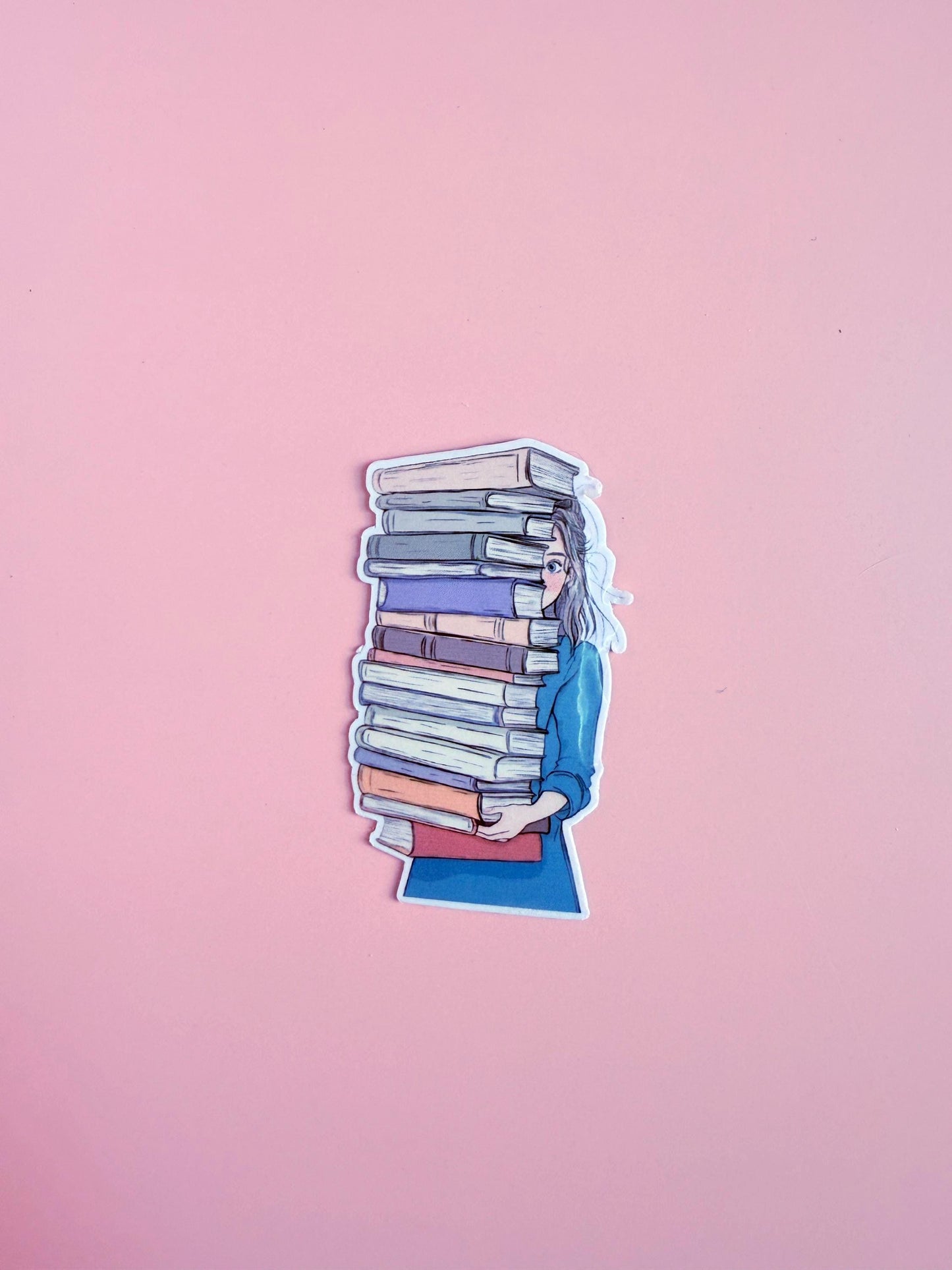 A vinyl sticker of a girl peeking to the side while holding a towering stack of books. A playful, bookish design perfect for readers, book hoarders, and cozy aesthetic fans decorating their journals, laptops, or Kindles.