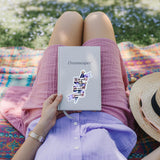 Reader in lavender holding a journal with a Powerless-inspired dagger quote sticker in a wildflower field, romantasy booktok scene, by The Sticker Era