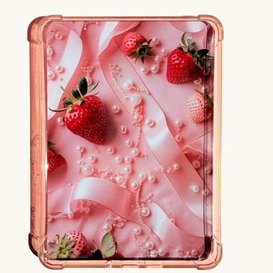 A printed Kindle insert with a coquette aesthetic, featuring red and white strawberries, pink satin ribbon, and scattered pearls on a pink background. The insert has soft lighting and a dreamy, feminine vibe. Photographed on a pastel surface with rounded corners.