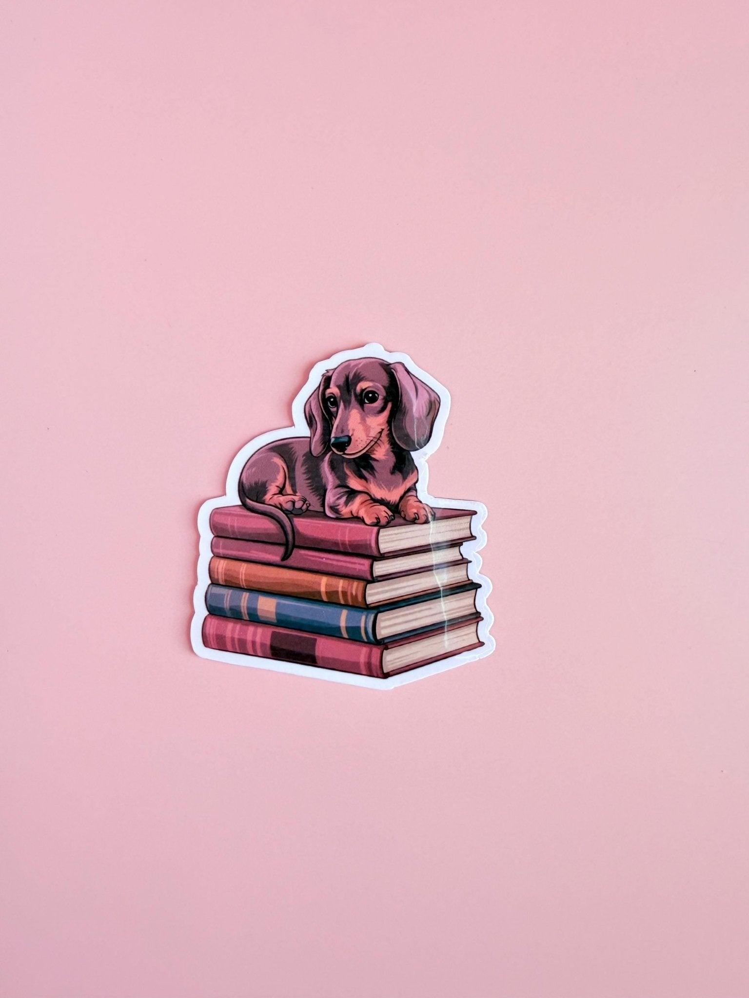 Dachshund on Books Sticker | Cute Bookish Dog Vinyl Decal by The Sticker Era