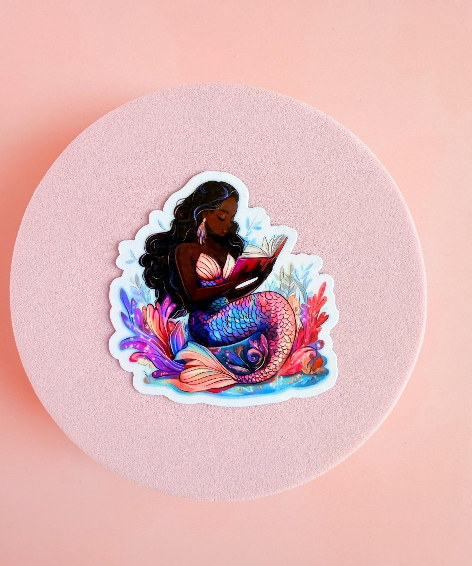 Bookish Black mermaid reading siren sticker close-up, by The Sticker Era