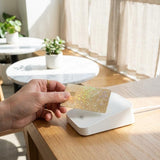 Gold glitter card skin being applied to a debit card by The Sticker Era