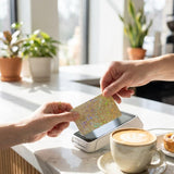 Sparkly gold credit card skin styled on a bright tabletop by The Sticker Era