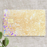 Close-up of the shimmering gold glitter vinyl card skin texture by The Sticker Era