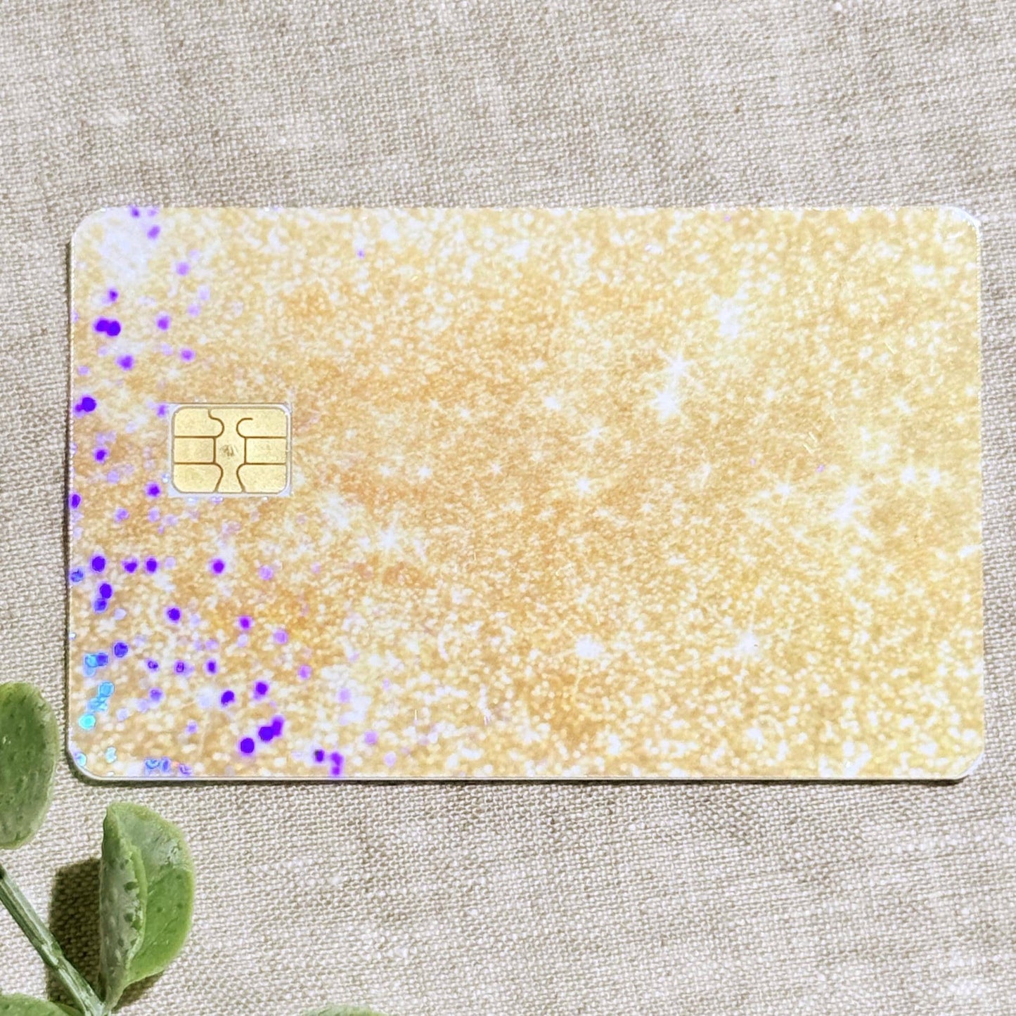 Close-up of the shimmering gold glitter vinyl card skin texture by 