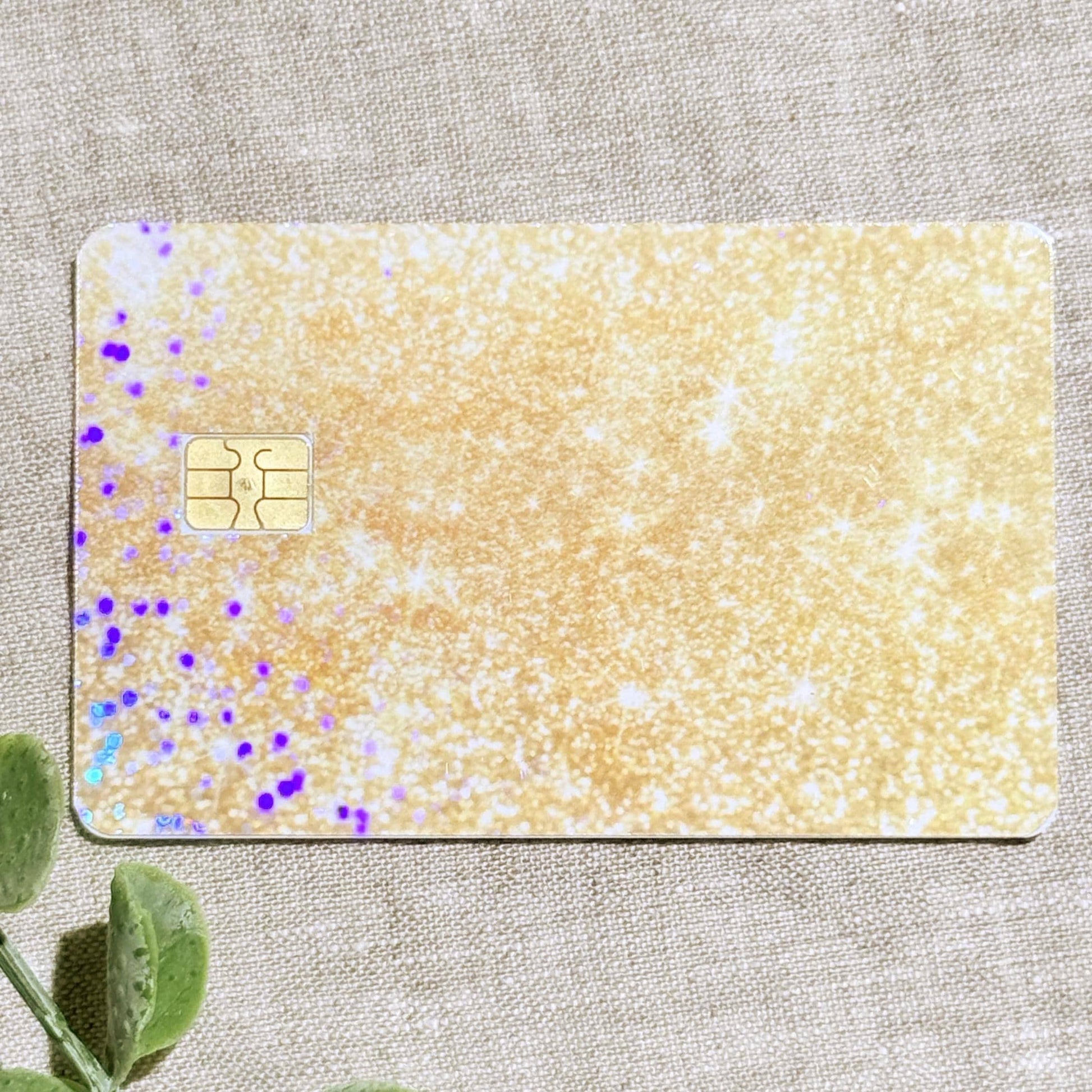 Close-up of the shimmering gold glitter vinyl card skin texture by 