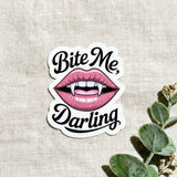 Vampire romance vinyl sticker with pink lips and fangs reading Bite Me Darling by The Sticker Era