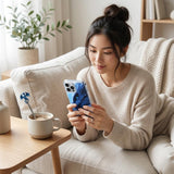 Woman on a couch using an iPhone with the blue dragon romantasy insert by The Sticker Era