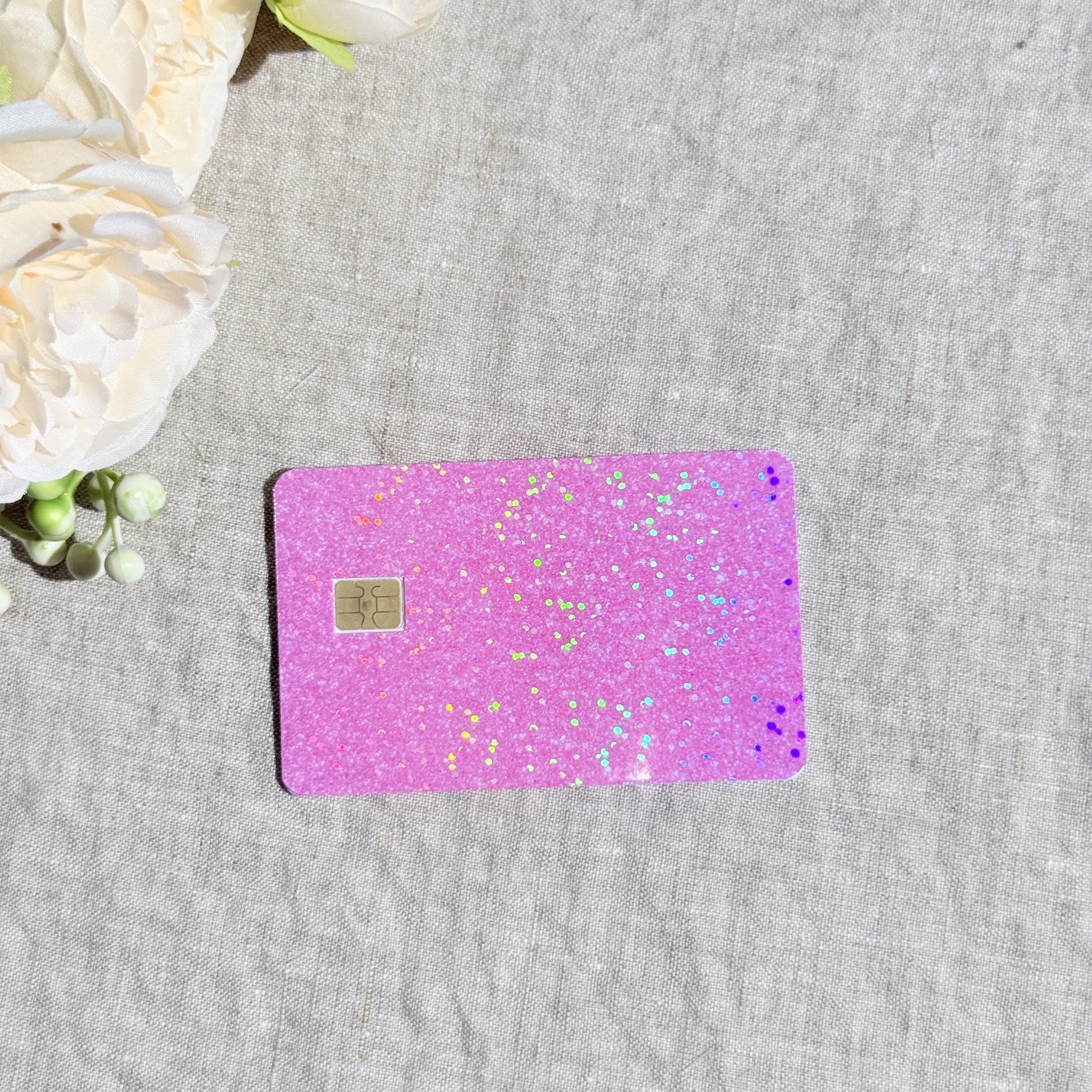 Light pink glitter card skin with holographic sparkle on a baby pink debit card by The Sticker Era