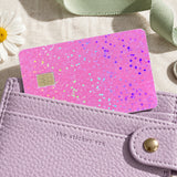 Pink glitter card skin tucked into a lilac card wallet with keys and a daisy by The Sticker Era