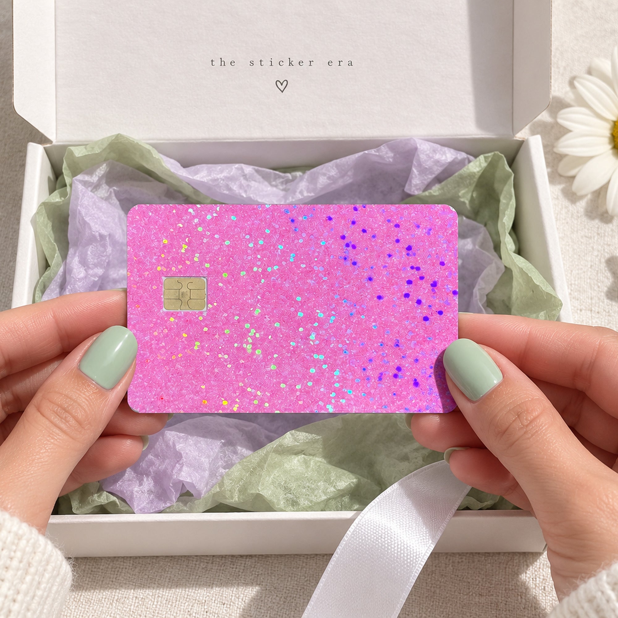 Hands unboxing the pink glitter debit card skin from The Sticker Era packaging
